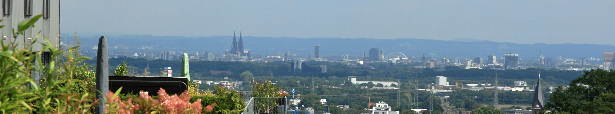 Das Bild zeigt einen Blick über die Frechener Innenstadt. Im Hintergrund ist Köln mit dem Dom zu erkennen.