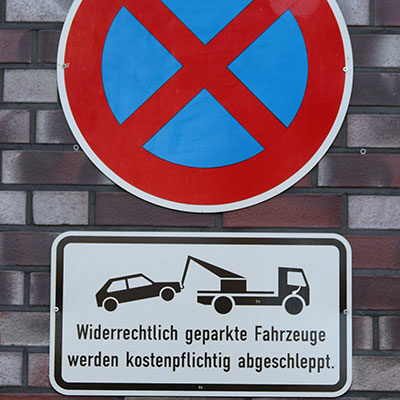 Auf dem Foto sehen Sie ein Verbotsschild: Absolutes Parkverbot. Darunter ist ein Schild, auf dem steht: Widerrechtlich geparkte Fahrzeuge werden kostenpflichtig abgeschleppt.