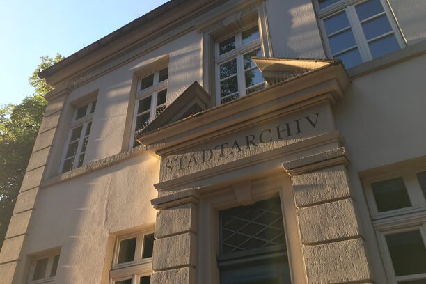 Das Bild zeigt die Fassade des Gebäudes, in dem das Stadtarchiv untergebracht ist. Es ist der Schriftzug STADTARCHIV darauf zu erkennen.