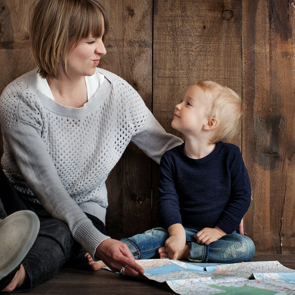 Das Foto zeigt eine Frau und ein Kind. Beide schauen sich eine Land- bzw. Straßenkarte an.
