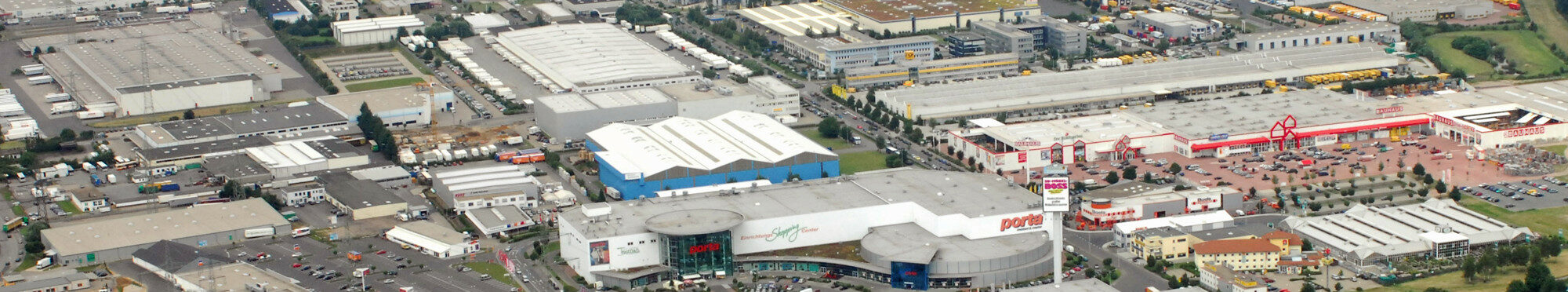 Die Aufnahme zeigt ein Luftbild mit großen Gebäudeinheiten im Bereich des Gewerbegebietes an der Europaallee.